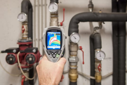 Plumber using a thermal imaging camera to inspect pipes in San Jacinto