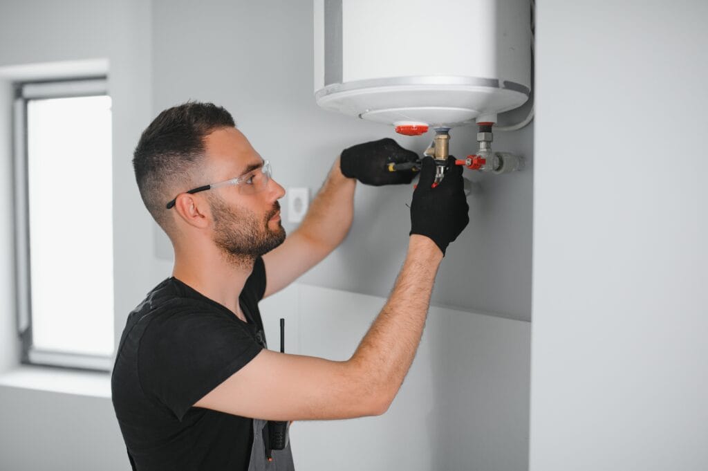 Technician performing water heater maintenance in San Jacinto